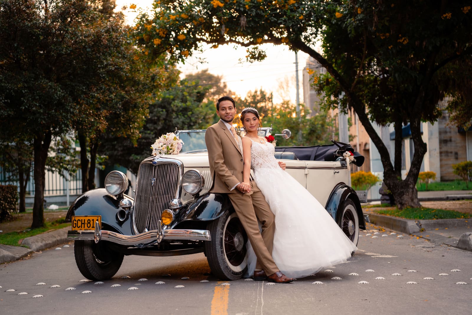 Pareja de novios abrazada a contraluz durante el atardecer.