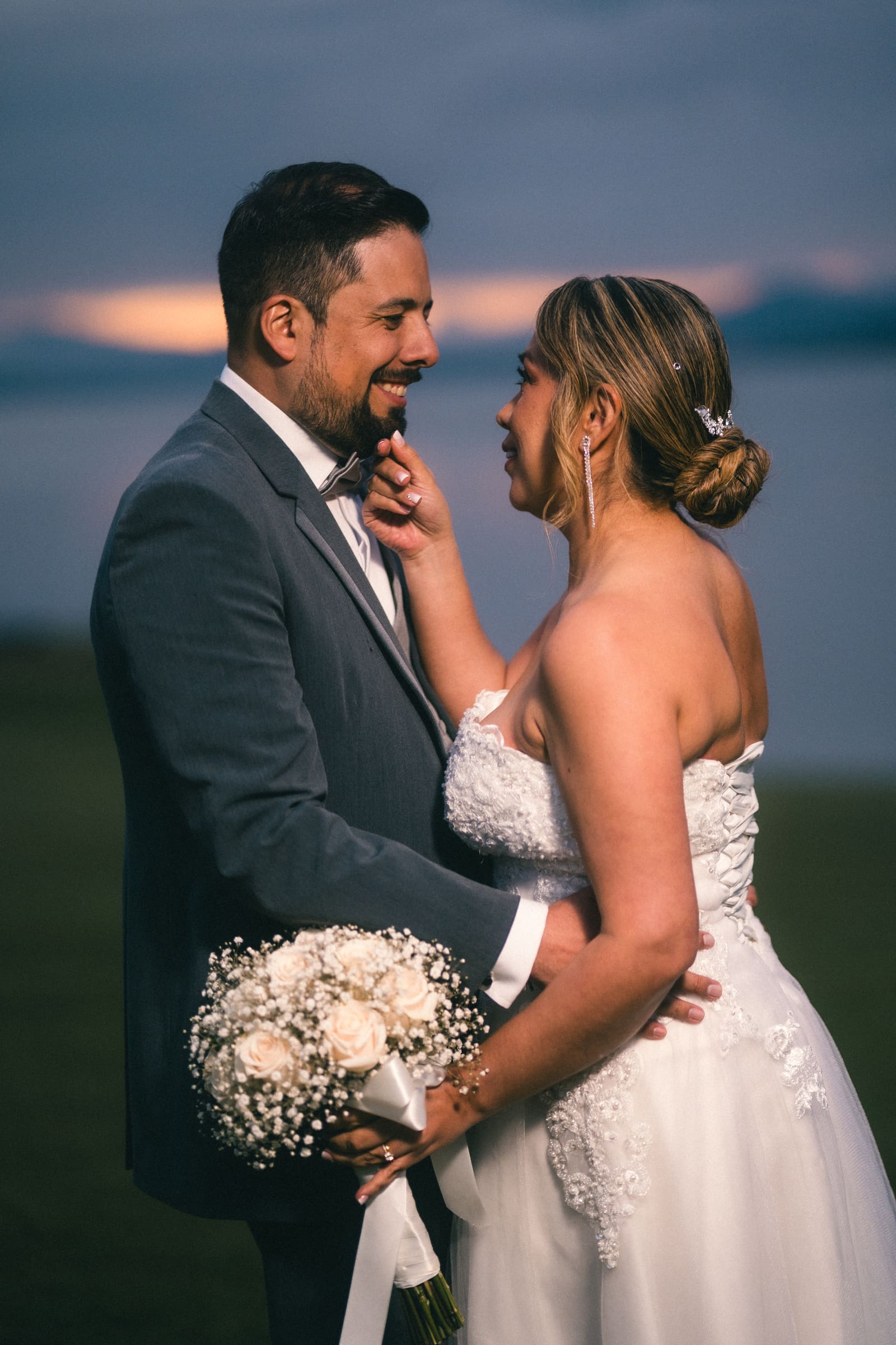 Retrato de la pareja abrazada a contraluz al atardecer