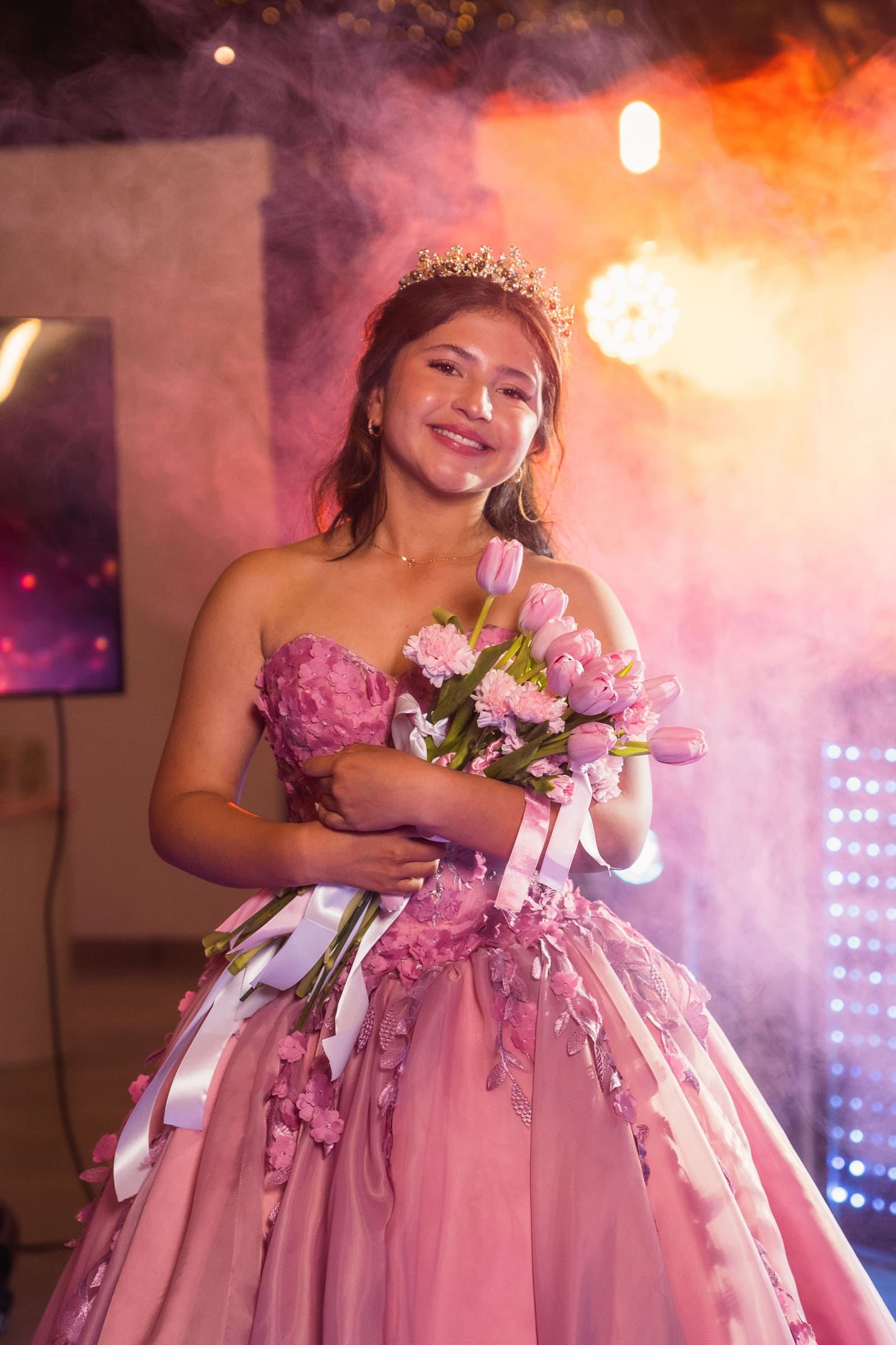 Quinceañera abrazando a su papá durante el vals, con luces cálidas
