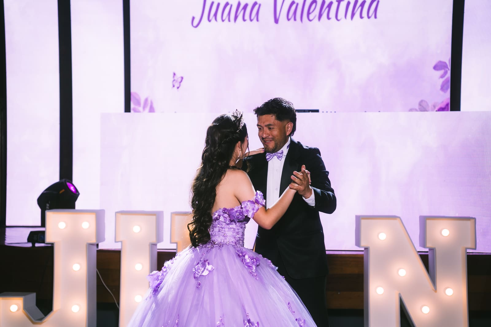 Vals de la quinceañera con su papá bajo luces cálidas
