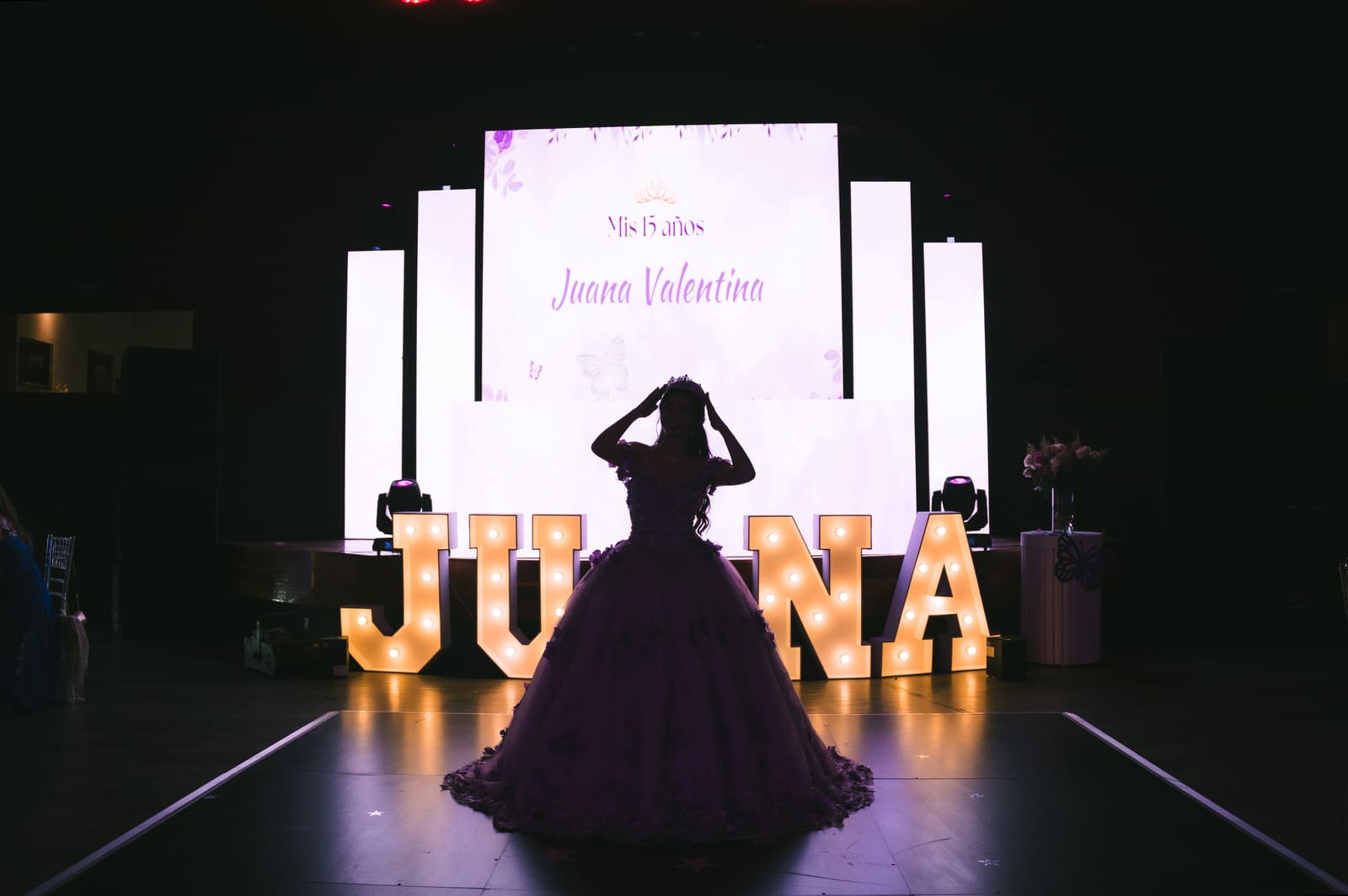 Juana durante su fiesta de 15 años en el Club Naval, Bogotá, con contraluz de las pantallas del salón