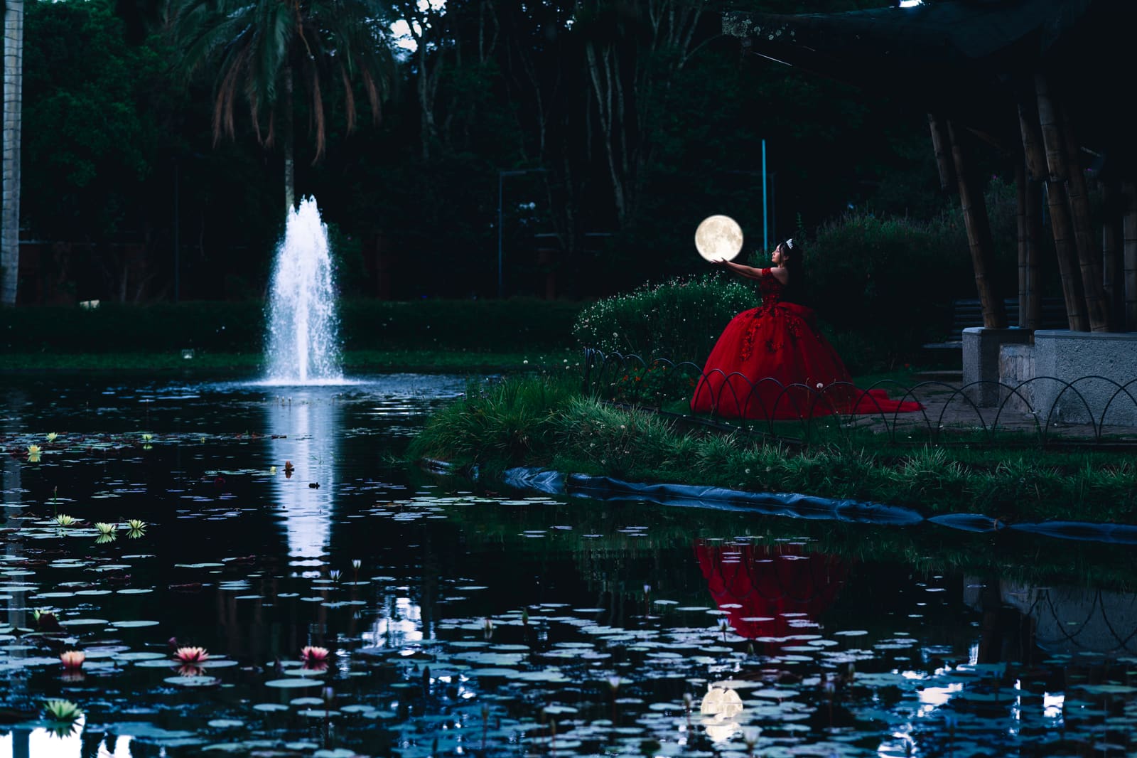 Quinceañera caminando entre árboles con vestido largo y luz de tarde